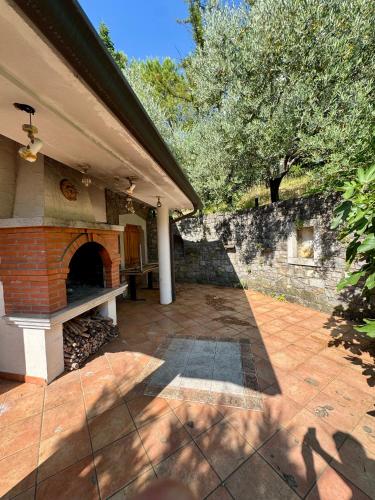 a patio with a brick fireplace on a house at Božič Residence in Vipava