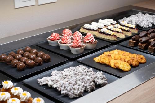 a bunch of different types of desserts on black trays at Barceló Marine Boa Vista - Adults Only in Sal Rei