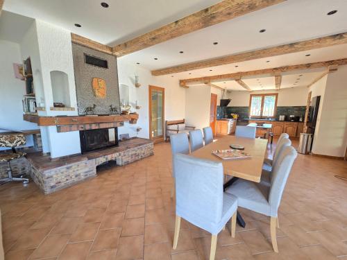 une salle à manger avec une table et des chaises et une cheminée dans l'établissement Les Oliviers Du Lac, à Esparron-de-Verdon