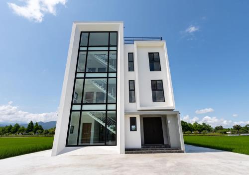 a white house with a large glass door at S island in Sanxing