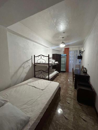 a bedroom with a bed and a table and a desk at Family hotel Khomaldy in Kvariati