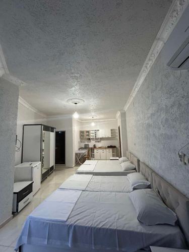 a bedroom with three beds and a kitchen at Family hotel Khomaldy in Kvariati