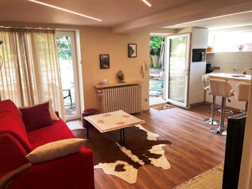 un salon avec un canapé rouge et une cuisine dans l'établissement appart privé dans villa meinau résidentiel, à Strasbourg