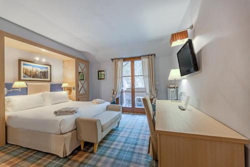 a hotel room with a bed and a living room at Val di Luce SPA Resort in Abetone