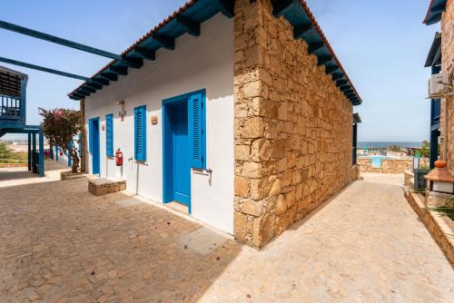 a building with blue doors and a brick wall at Barceló Marine Boa Vista - Adults Only in Sal Rei