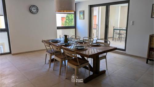a dining room with a wooden table and chairs at La Petite Vue, Logement Climatis in Rouffach