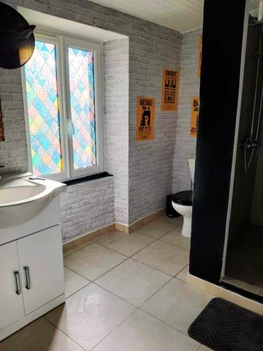 a bathroom with a toilet and a sink and a window at Séjour de sorcier Clim et Jardin in Saint-Privat