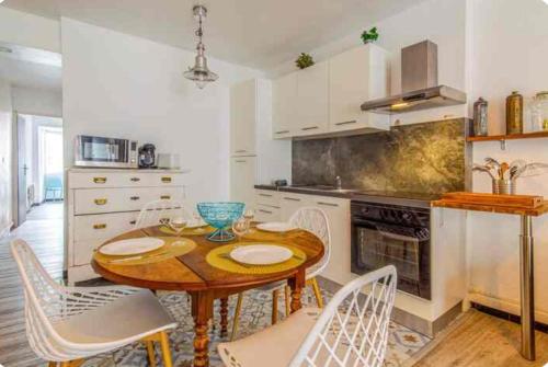 une cuisine avec une table en bois et des armoires blanches dans l'établissement 