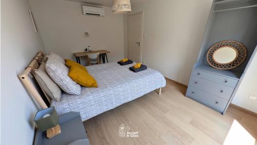 a bedroom with a bed with a mirror and a dresser at La Petite Vue, Logement Climatis in Rouffach