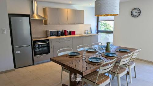 a kitchen with a wooden table with chairs around it at La Petite Vue, Logement Climatis in Rouffach