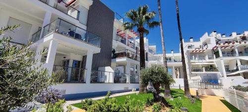un edificio de apartamentos blanco con gente en el balcón en Sunny Denia Apartment 4U - Mar Baltic 5, en Denia