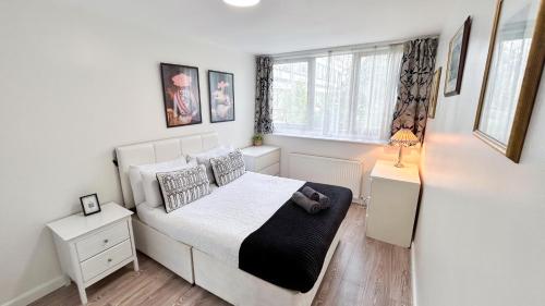 a small bedroom with a bed and a window at Spacious Maida Vale Apt with Private Garden near Little Venice & Paddington by Staylio London in London