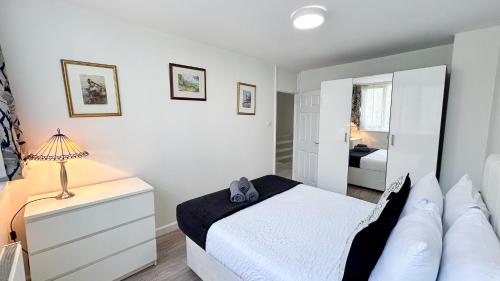 a white bedroom with a bed and a mirror at Spacious Maida Vale Apt with Private Garden near Little Venice & Paddington by Staylio London in London