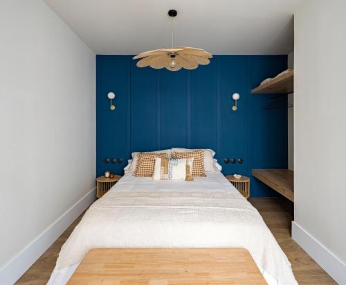 a bedroom with a large bed with a blue wall at La Casa del Caballero in Cartagena