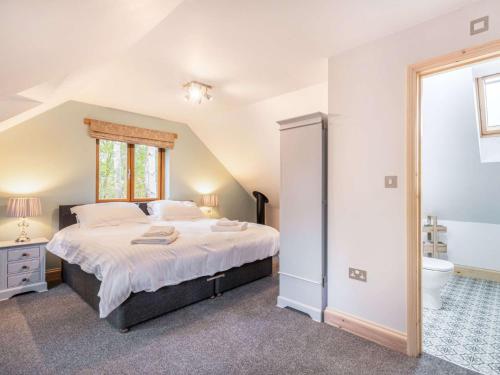a bedroom with a large bed and a bathroom at 2 bed in Dereham 86115 in Bawdeswell