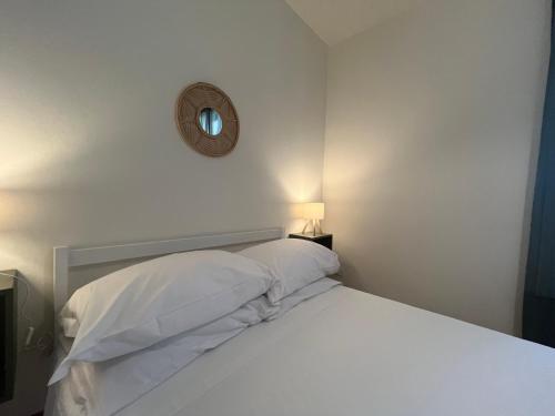 a bedroom with a bed with white sheets and a mirror at CASA DORA sunflower apartment in Fucecchio