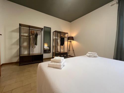 a bedroom with a white bed with towels on it at CASA DORA sunflower apartment in Fucecchio