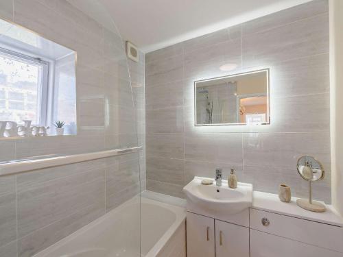 une salle de bain blanche avec un lavabo et une baignoire dans l'établissement 2 Bed in Woolacombe 83425, à Woolacombe