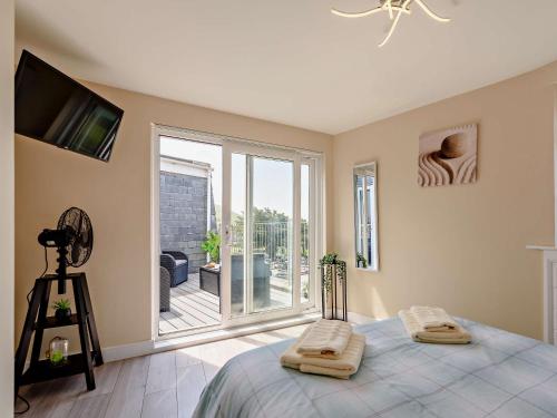 - une chambre avec un lit et un balcon avec une télévision dans l'établissement 2 Bed in Woolacombe 83425, à Woolacombe
