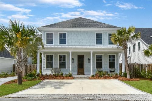 a white house with palm trees in front of it at 21 Orchard Road in Island Retreat