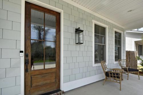 a porch with a wooden door and a table and chairs at 21 Orchard Road in Island Retreat