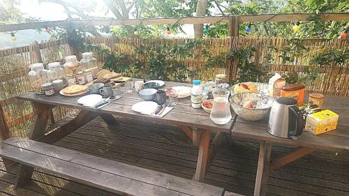 a wooden picnic table with food on top of it at CROUXETO Chambres d'hôte in Duilhac