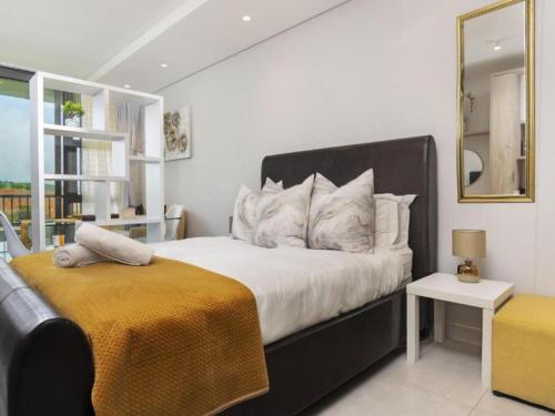 una camera da letto con un letto grande e uno specchio di Zimbali Lakes Boulevard Suite, Euphoric Leisure a Ballito