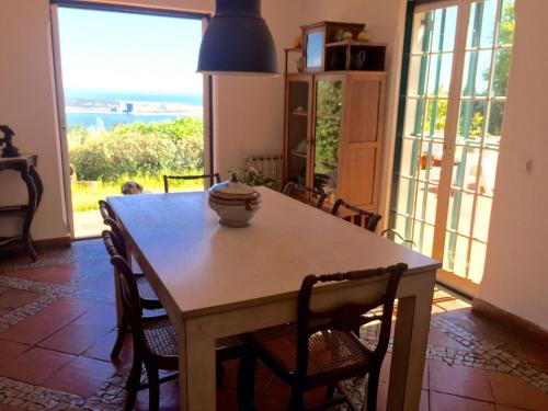 a dining room with a table and chairs with a view at Ha Mar ao Luar in Setúbal