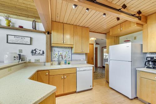a kitchen with wooden cabinets and a white refrigerator at 1 Mi to Dtwn Red Lodge Mtn-View Cabin Getaway in Red Lodge