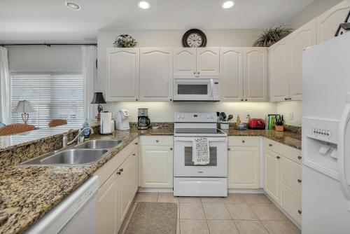 a kitchen with white cabinets and a sink at Windward Point 210 in Harrington