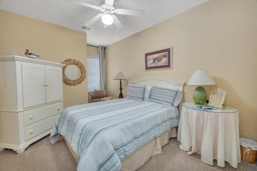a bedroom with a bed with a white dresser and a table at Windward Point 210 in Harrington