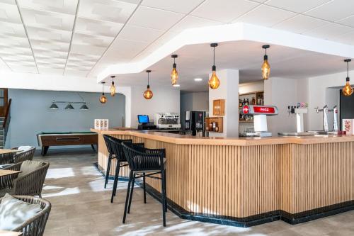 a restaurant with a bar with chairs around it at FERGUS Club Carema Splash in Fornells