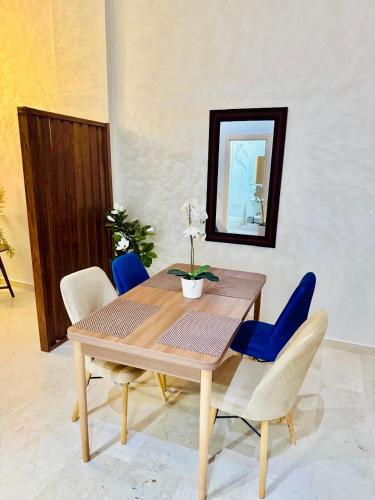 a dining room table with blue chairs and a mirror at Casablanca Luxury Studio Apartment Steps to the Beach in Casablanca
