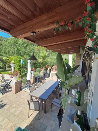 a patio with a table and chairs under a wooden roof at Villa Giselda con idromassaggio in Formia