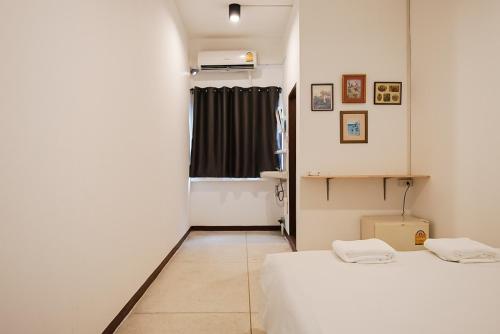 a small room with two beds and a window at GO INN Asiatique BKK - โกอินน์ เอเชียทีค เจริญกรุง in Godown