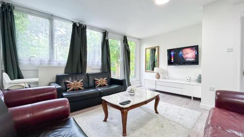 a living room with a couch and a table at Spacious Maida Vale Apt with Private Garden near Little Venice & Paddington by Staylio London in London