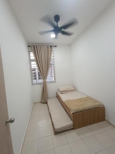 a bedroom with a bed and a ceiling fan at Ittizan homestay, Alor Gajah in Kampong Jelatang