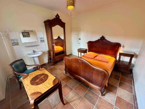 a bedroom with a bed and a mirror and a table at Charmante maison à Laure-Minervois avec piscine et jardin in Laure-Minervois
