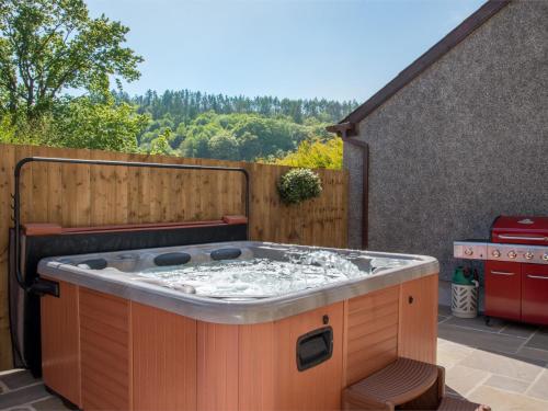a hot tub sitting on top of a patio at 4 Bed in Ystradgynlais BN343 in Ystalyfera