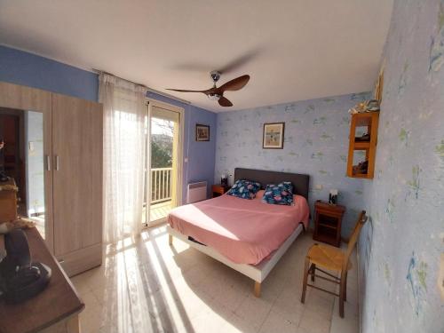 Un dormitorio con una cama y un ventilador de techo. en DUPLEX T3 Terrasse proche mer, en Narbonne-Plage