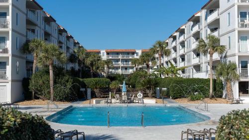 a swimming pool in front of a apartment building at Beach Club 203 in East End
