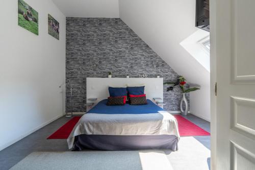 a bedroom with a bed and a brick wall at A 2 pas d AZAY in Neuil