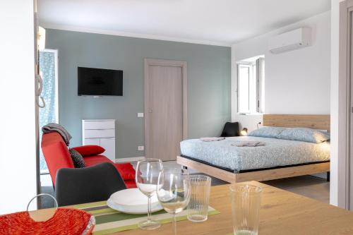 a bedroom with a bed and a table with wine glasses at Casa Quadrifoglio - Valgrande in Intra