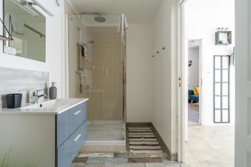 a bathroom with a shower and a white sink at A 2 pas d AZAY in Neuil