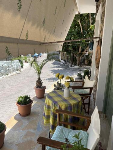 a patio with a table and chairs and potted plants at Katerina's Home in Ancient Epidavros