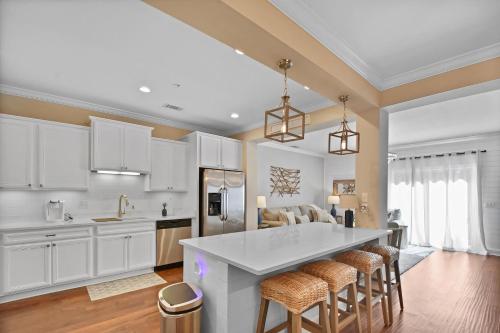 a kitchen with white cabinets and a kitchen island with bar stools at Coastal Escape in Jewtown