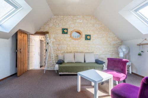 a attic room with a bed and a table and chairs at A 2 pas d AZAY in Neuil