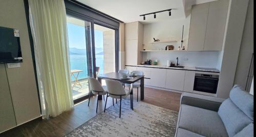 a kitchen and living room with a table and chairs at Azurno Pristaniste 2 in Španjola