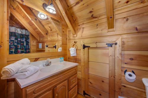 a bathroom with a sink in a wooden cabin at The Vinson By Avada Properites in Gatlinburg