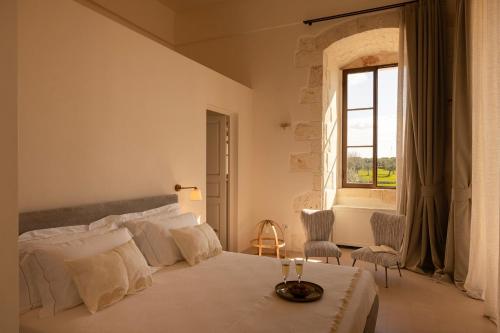 a white bedroom with a bed and a window at Masseria Tarsia Morisco in Polignano a Mare